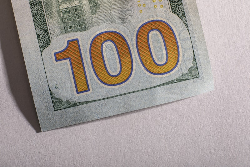 Close-up detail of a U.S. one hundred dollar bill showing Benjamin Franklin's portrait, highlighting the fine details collectors examine